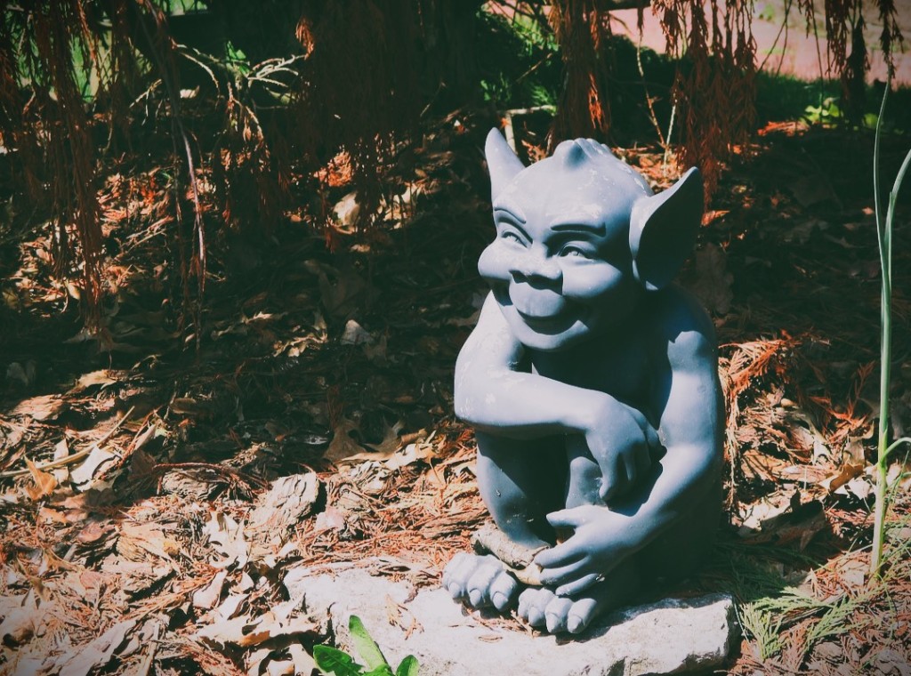 A statue of a goblin with a sneaky grin
